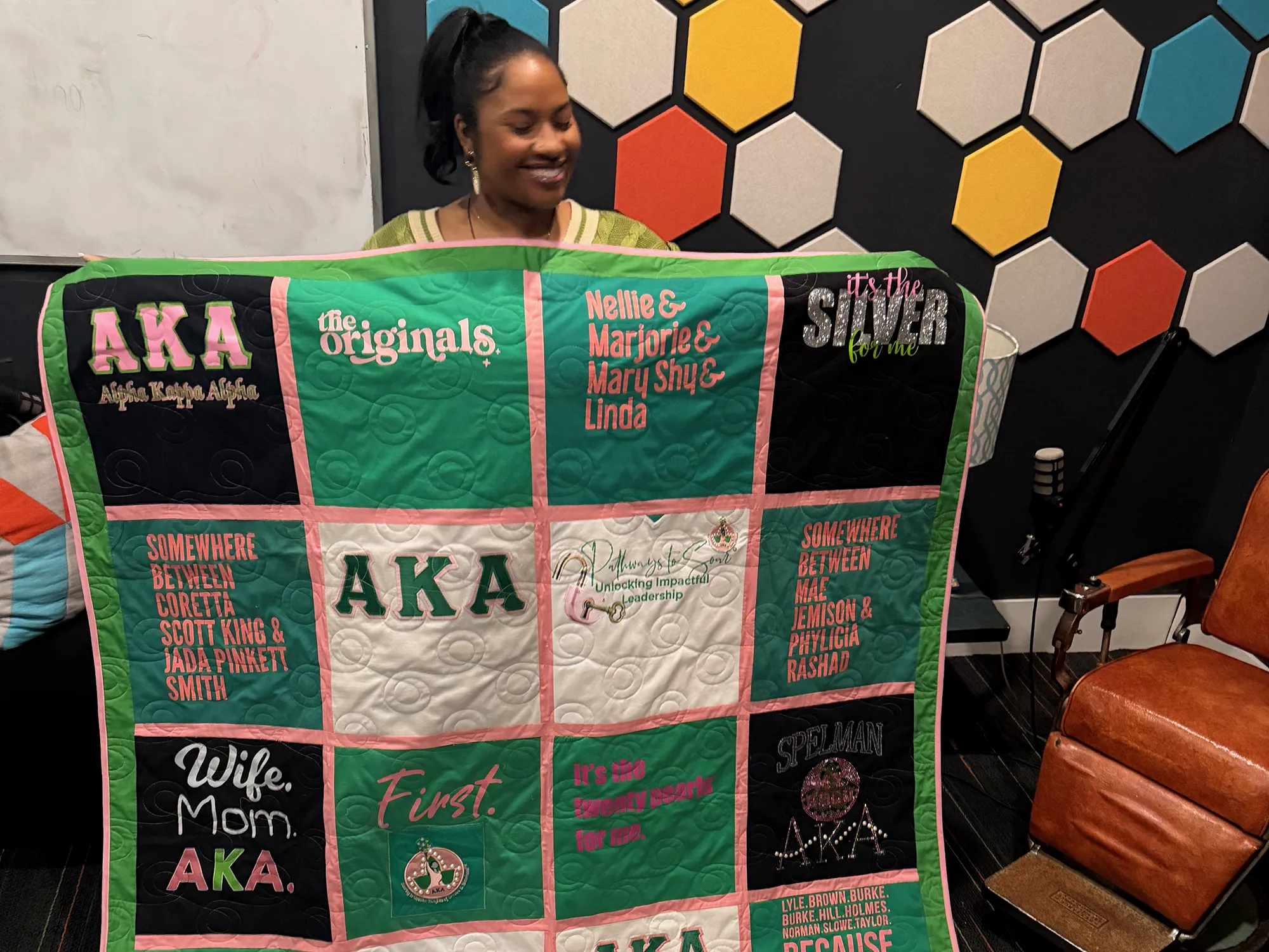 Finished AKA sorority memory quilt with pink sashing and green border made from 20 shirts spanning 40 years, created by Wesley Hall at Quilts by Big Wes in Atlanta GA