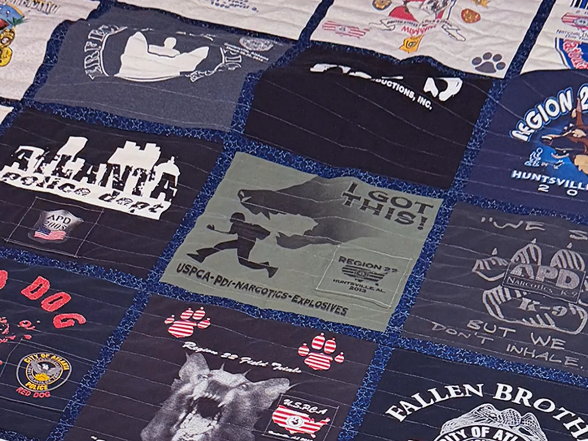 Finished full-size K9 officer career memory quilt laid out flat, made from Atlanta Police Department t-shirts by Quilts by Big Wes