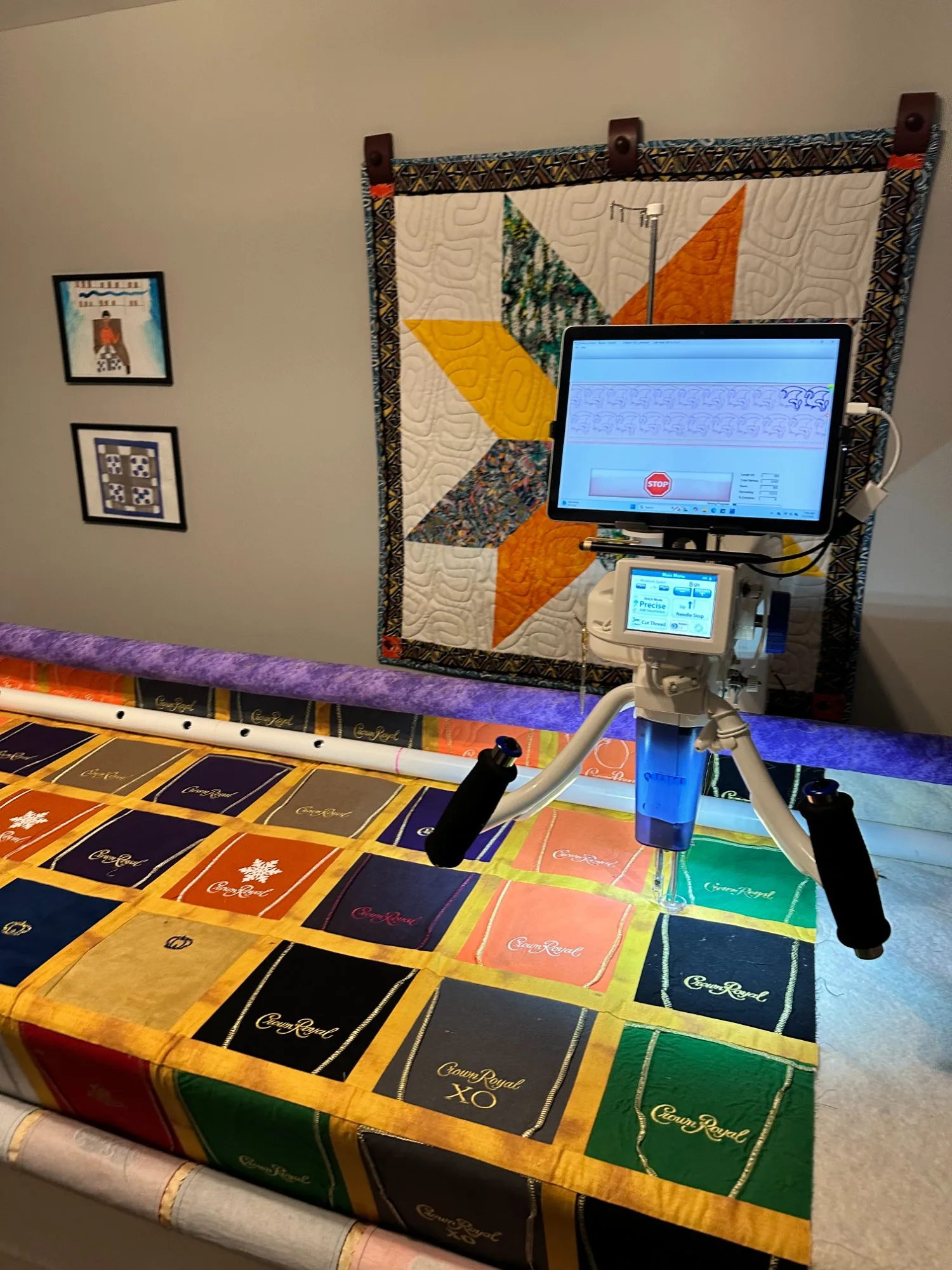 Computerized long arm machine quilting a colorful Crown Royal bag quilt with gold trim and bold purple, blue, and green blocks