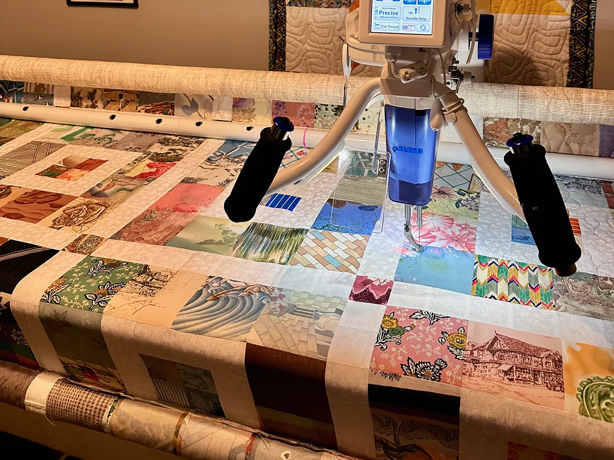 Computerized longarm quilting machine loaded with a quilt top in Wesley Hall's Atlanta studio, showing the full frame and machine head