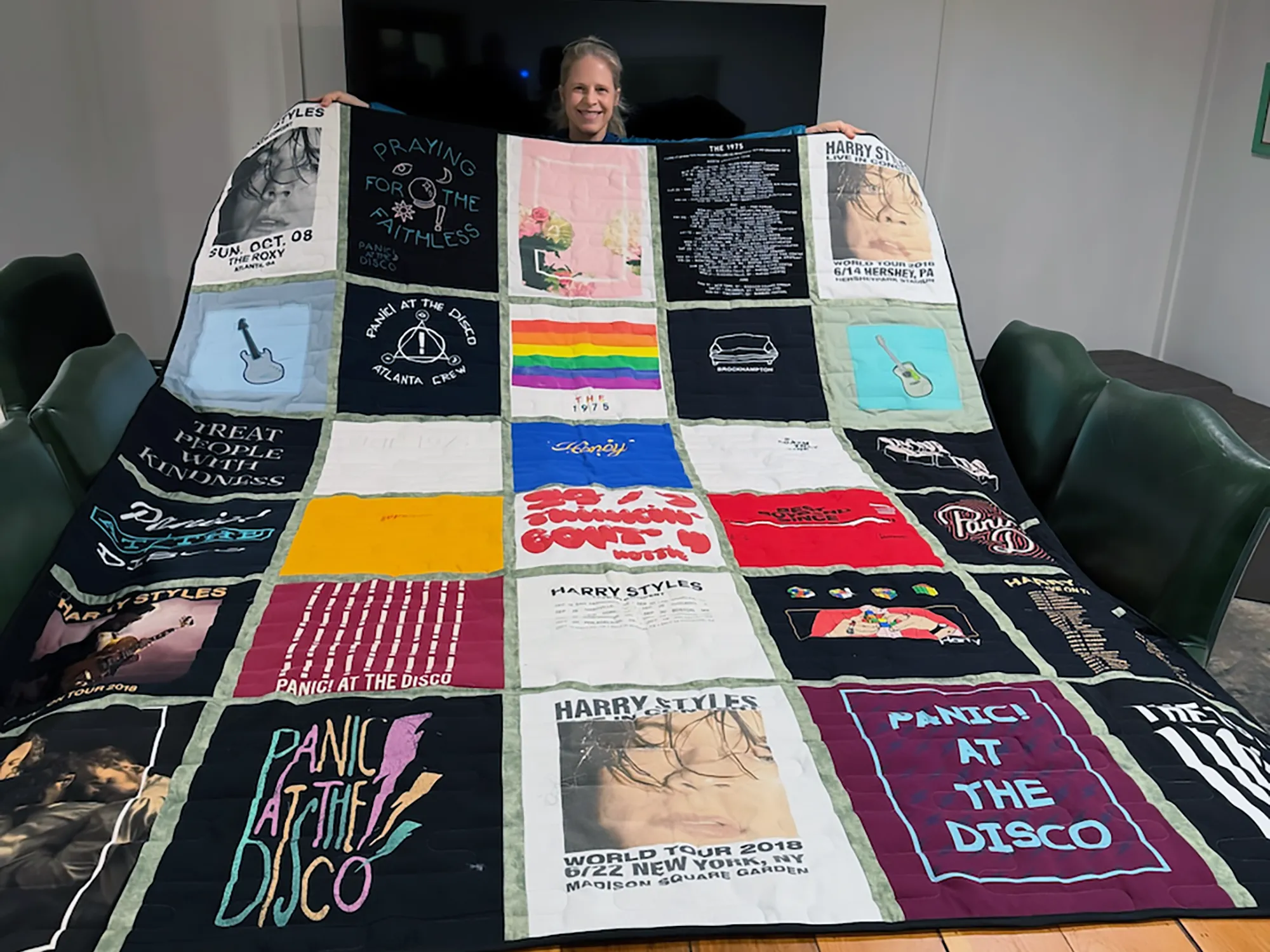 Finished concert t-shirt quilt displayed in Wesley Hall's Atlanta quilting studio, made from thirty band tees with dark sashing fabric