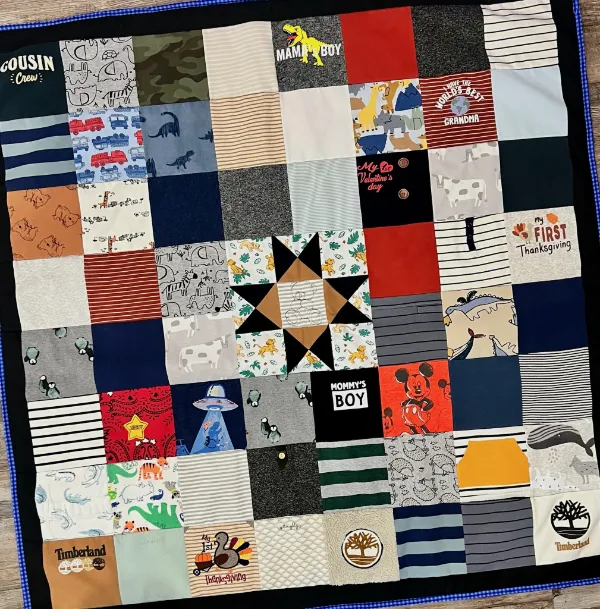 Baby clothes memory quilt with a central Ohio star block, made from infant onesies and toddler shirts including Mickey Mouse and Timberland, handmade in Atlanta