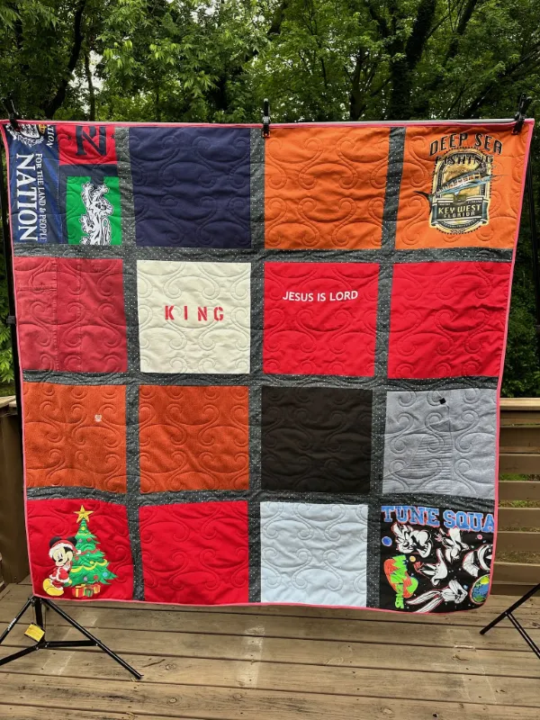 Custom t-shirt quilt with mixed shirts including faith, Disney Mickey Mouse Christmas, Key West fishing, and Space Jam Tune Squad, displayed outdoors in Atlanta