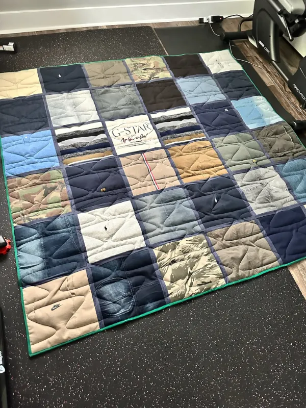 Men's clothing memory quilt made from Polo Ralph Lauren, Nike, G-Star Raw, camouflage, and denim pieces, displayed flat in Atlanta by Quilts by Big Wes