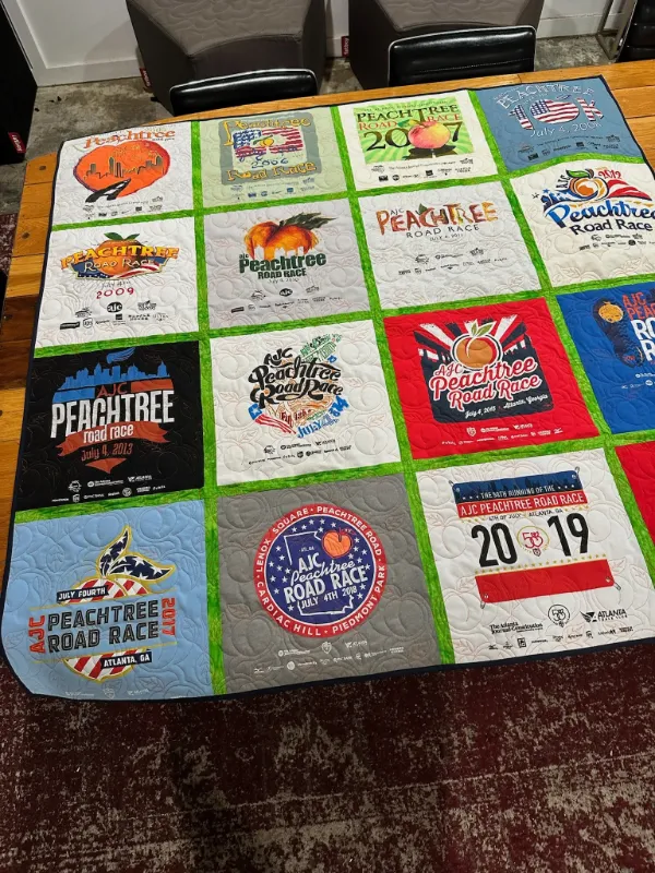 AJC Peachtree Road Race t-shirt quilt featuring race shirts from multiple years with bright green sashing, handmade in Atlanta by Quilts by Big Wes