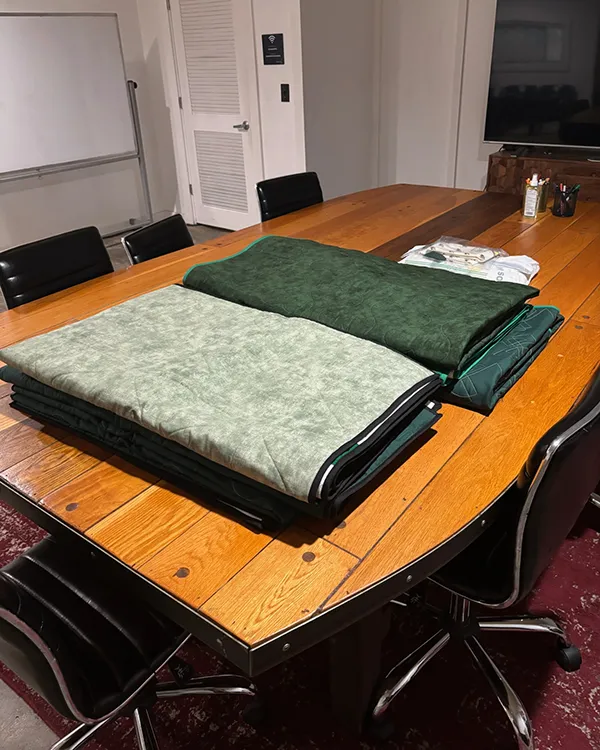 Reading wrapped in a custom quilt by Quilts by Big Wes, featuring an Atlanta jersey panel, denim piecing, varsity lettering, and African wax print sashing