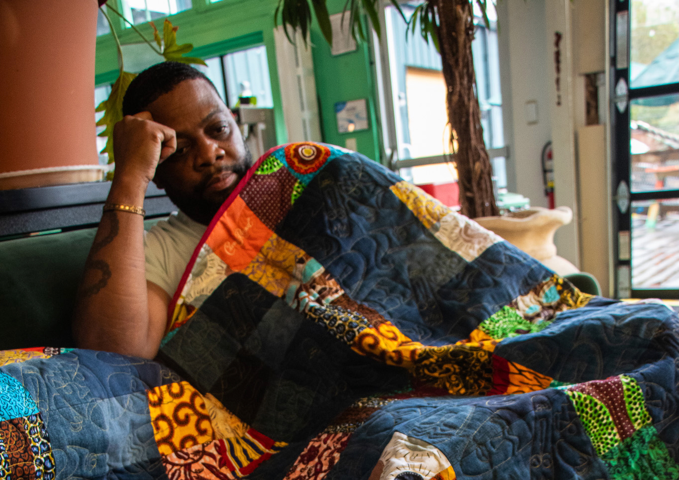 A man wrapped in a colorful quilt